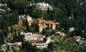 Il Vittoriale degli Italiani, un complesso monumentale immerso nel verde, con edifici storici, un anfiteatro e giardini lussureggianti.