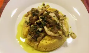 Delizioso luccio alla gardesana su un letto di polenta, condito con erbe aromatiche e olio d'oliva.