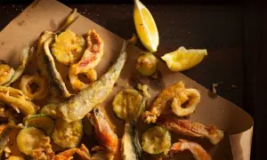 Fritto misto di mare e verdure, croccante e dorato, perfetto con il suo olio per frittura di pesce. Limone a spicchi per un tocco fresco.