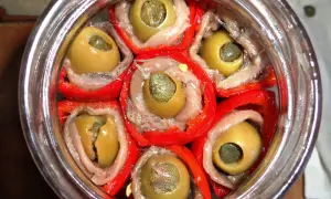 Peperoni sott'olio con acciughe e capperi, un antipasto saporito e colorato, pronto per essere gustato.