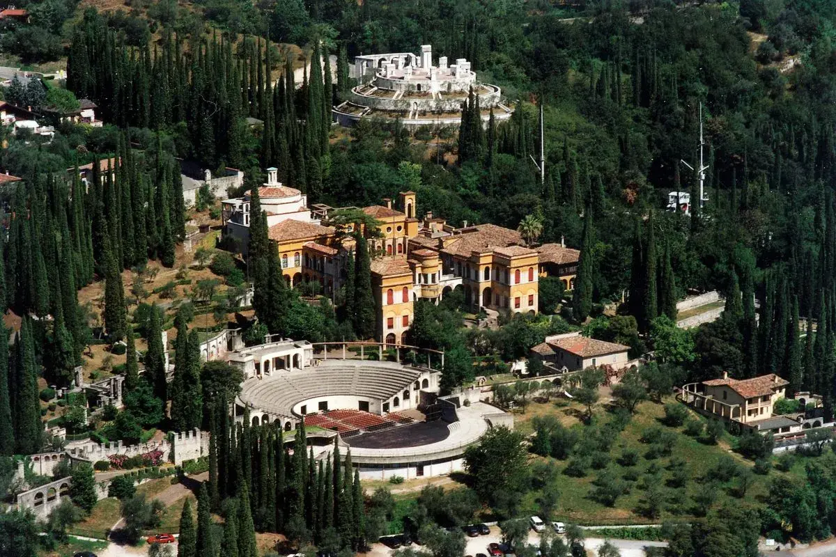 Il Vittoriale degli Italiani, un complesso monumentale immerso nel verde, con edifici storici, un anfiteatro e giardini lussureggianti.