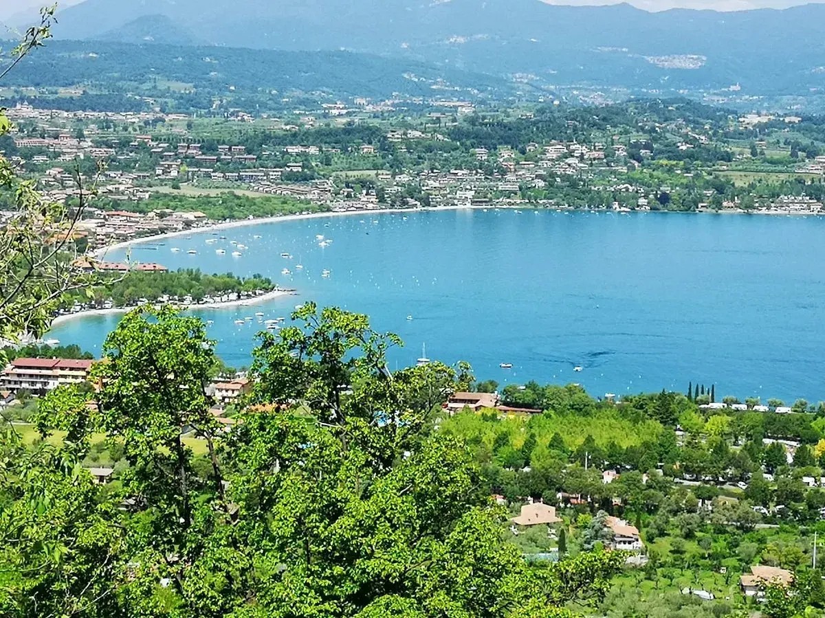 Vista panoramica di Manerba del Garda con il lago azzurro e le colline verdi.