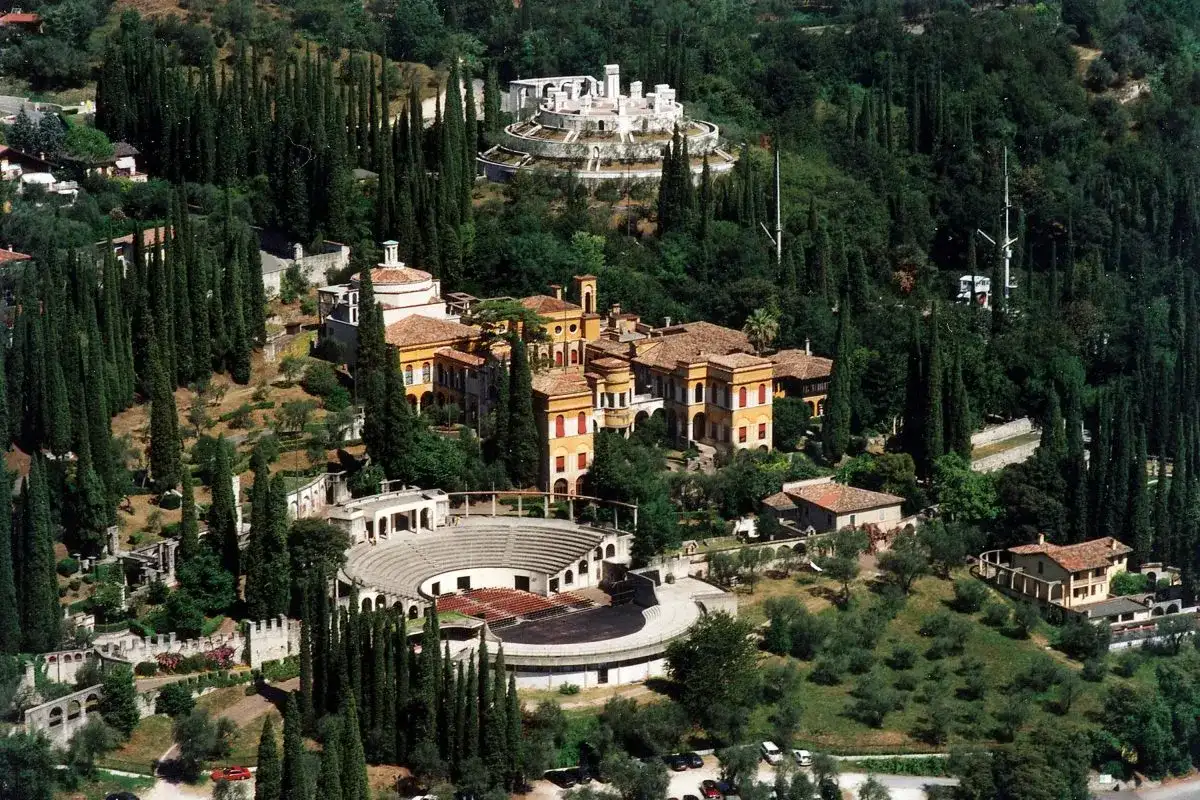 Il Vittoriale degli Italiani, un complesso monumentale immerso nel verde, con edifici storici, un anfiteatro e giardini lussureggianti.