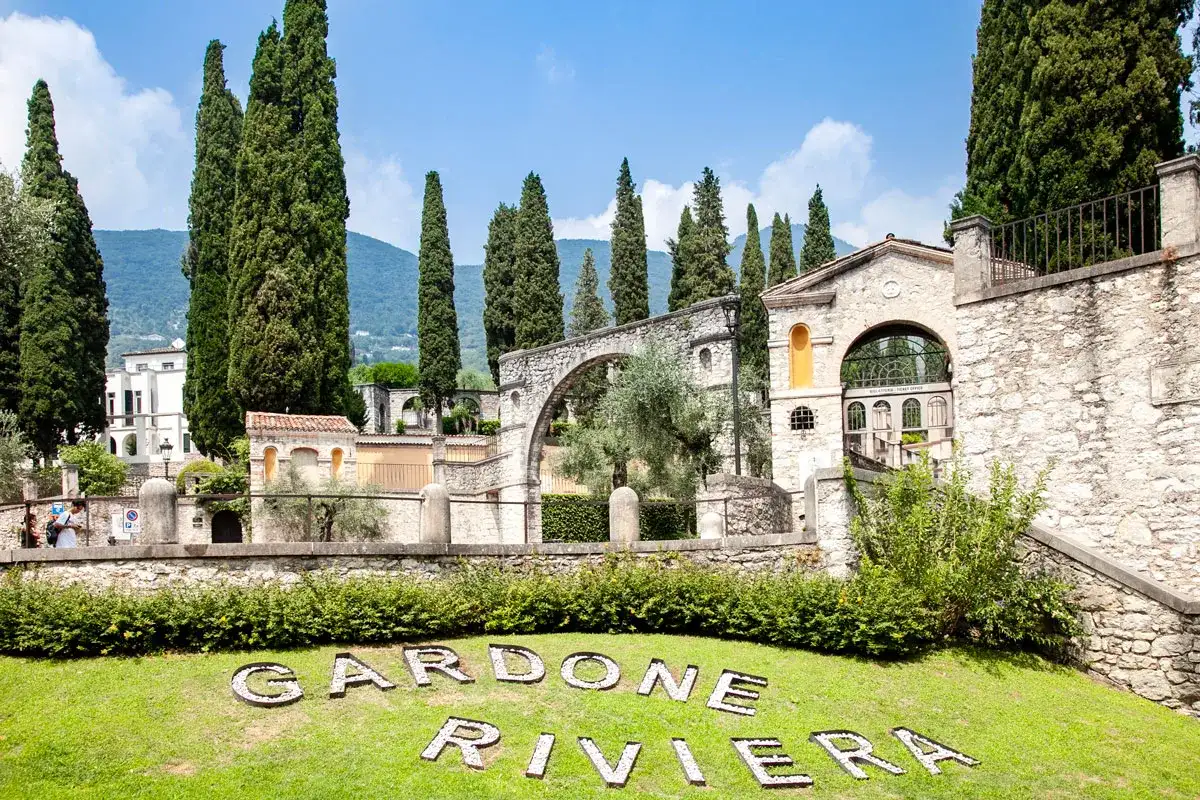 Un'oasi verde a Gardone Riviera, con cipressi svettanti, architetture in pietra e il nome della località inciso sull'erba.