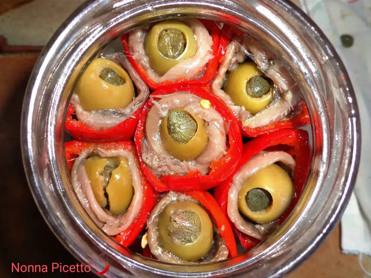 Peperoni sott'olio con acciughe e capperi, un antipasto saporito e colorato, pronto per essere gustato.