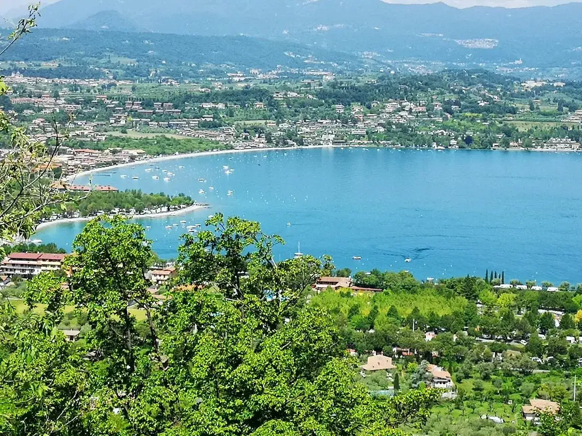 Vista panoramica di Manerba del Garda con il lago azzurro e le colline verdi.