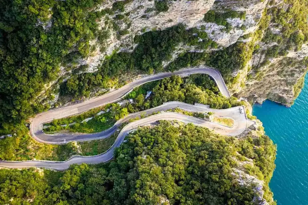 La strada della Forra serpeggia tra rocce e vegetazione lussureggiante, con curve mozzafiato a picco sul mare blu intenso.