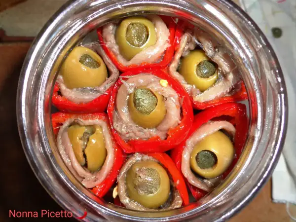 Peperoni sott'olio con acciughe e capperi, un antipasto saporito e colorato, pronto per essere gustato.